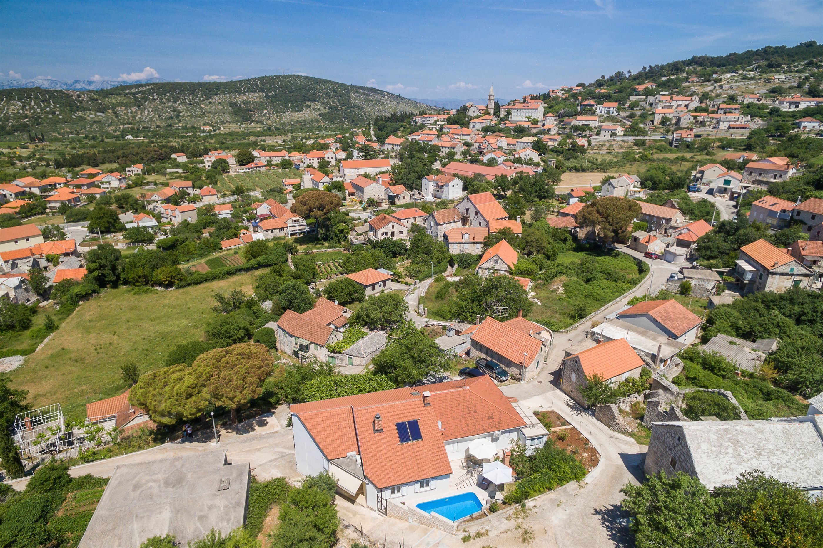 A residential area with houses, a swimming pool, and a church.