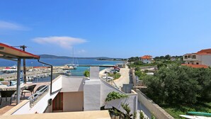 A coastal view with a marina, boats, and residential buildings. - Apartment Marija (Trogir)