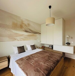 A bedroom with a bed, bedside tables, a large abstract painting, a wardrobe, and a hanging light fixture. - Apartment Renci (Biograd na Moru)