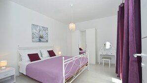A bedroom with a bed, bedside table, dresser, and a mirror. - House Pazanin (Marina)