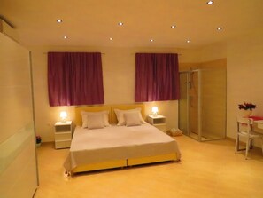 A bedroom with a bed, two nightstands, a bedside table, a shower, and a small desk with a chair. - House Villa Barakokula (Lumbarda)