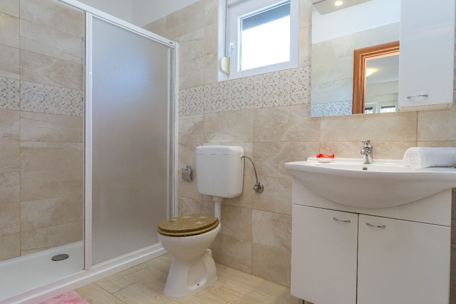 Un baño con inodoro, lavabo y espejo.