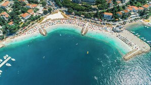 An aerial view of a coastal town with a beach, boats, and buildings. - Apartments Ani (Crikvenica)