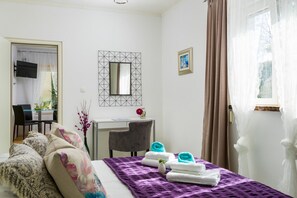 A bedroom with a bed, a desk, a chair, a mirror, and a window with curtains. - Apartment Jurica (Kastela)