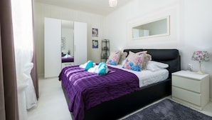 Un dormitorio con cama, mesitas de noche, un espejo y un armario.