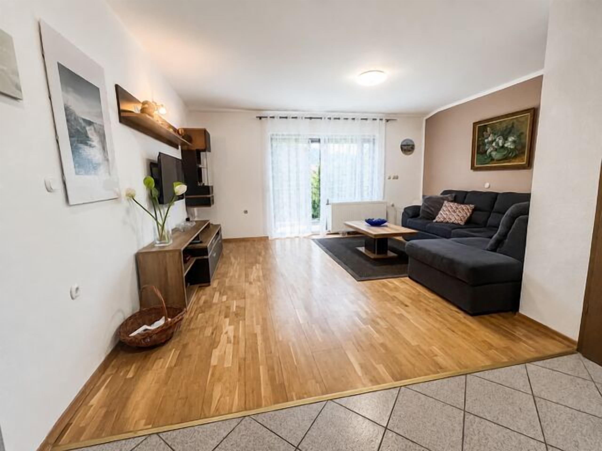 A living room with a sofa, a coffee table, and a TV stand.