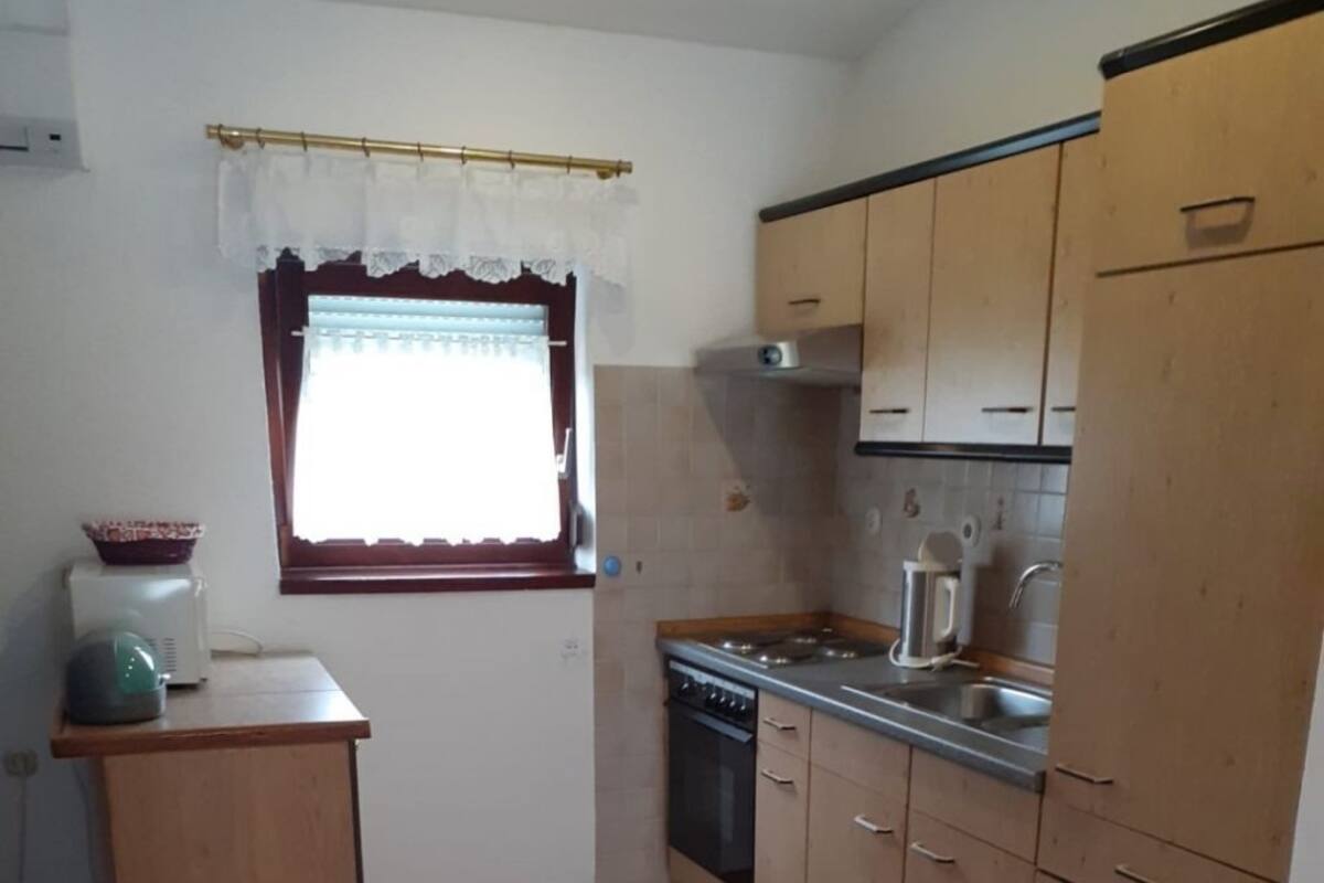 A compact kitchen with a stove, sink, and cabinets.