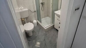 Une salle de bain moderne avec une douche à parois de verre, des toilettes et un lavabo.