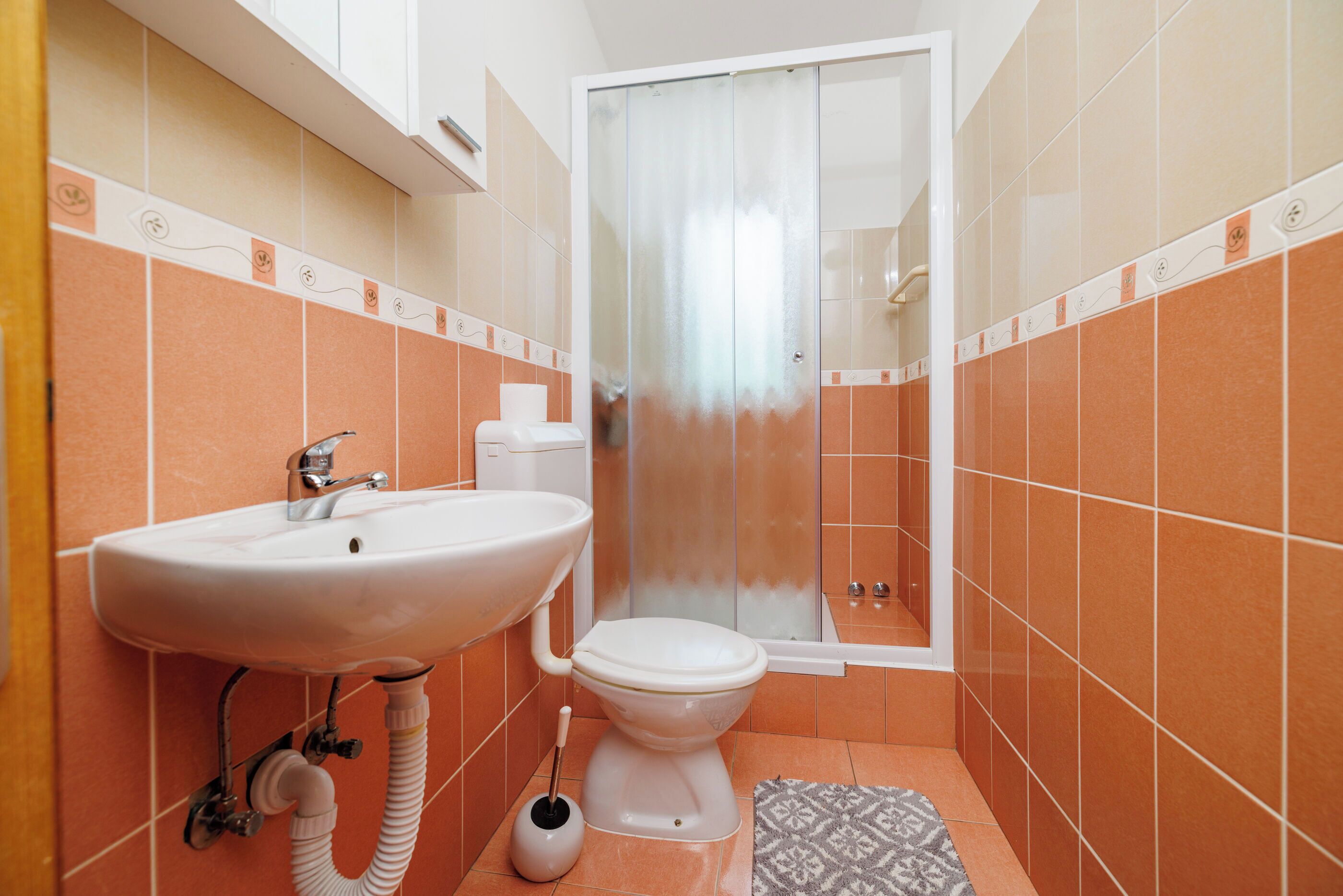 A bathroom with a sink, toilet, and shower.