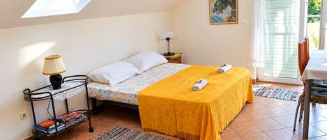 Une chambre à coucher avec un lit, des tables de chevet, une lampe, une fenêtre et un tableau.