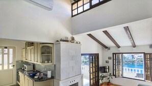 A spacious kitchen with a fireplace, a dining area with a view of the sea, and a living room with a large window overlooking the ocean. - Apartments Branka (Rogoznica)