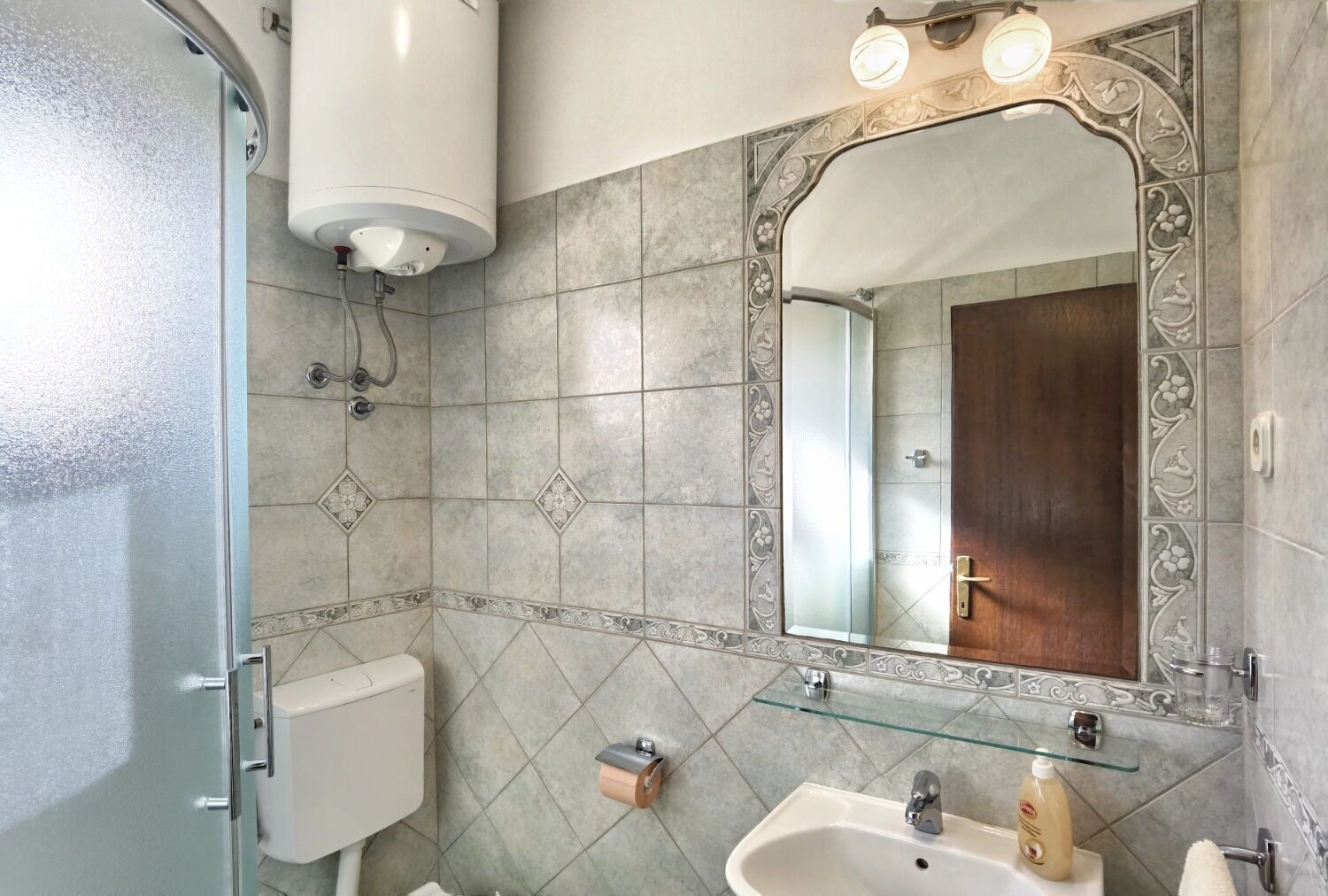 Une salle de bain équipée de toilettes, d’un lavabo et d’une douche.