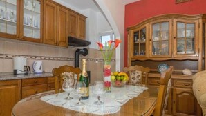 A dining table set with wine glasses, a bottle of champagne, and a vase with flowers. - Apartments Mari (Marina)
