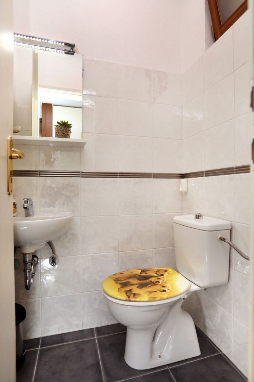 Un bagno con il water, un lavandino e uno specchio.