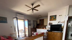 A compact living space with a kitchenette, a dining area, and a bedroom. - Apartment Jakov (Okrug)