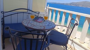 A balcony with a table and chairs, a magazine, and two glasses of beer. - Apartments Antonia (Okrug)