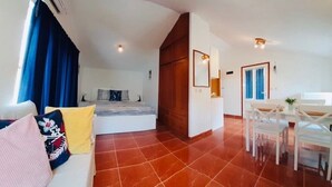 Una sala moderna con sofá, una mesa de comedor y una zona de cocina.