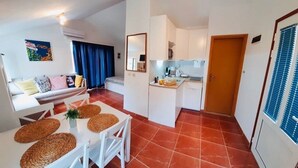 Un espacio habitable compacto con comedor, kitchenette y sofá.