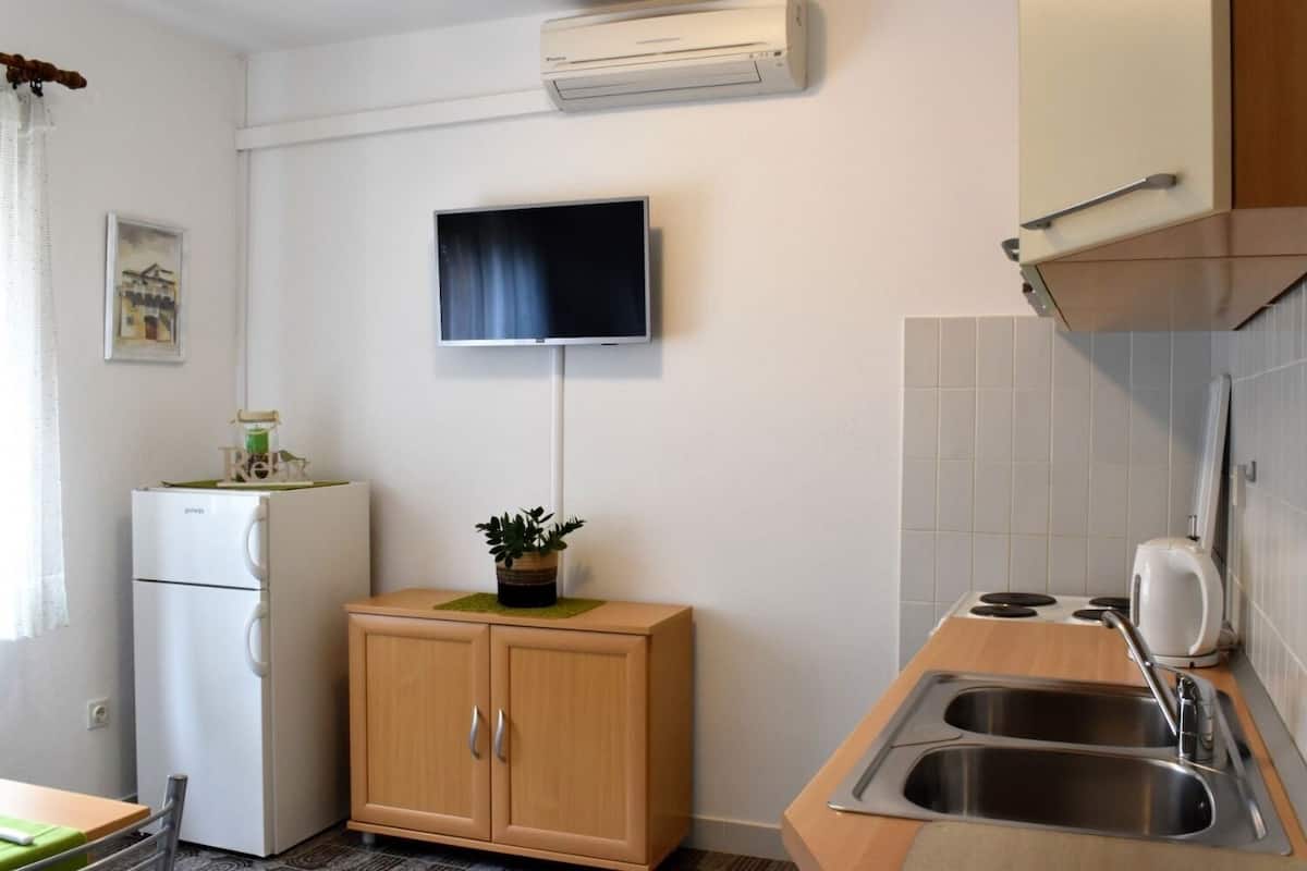 A compact kitchenette with a refrigerator, a sink, and a microwave.