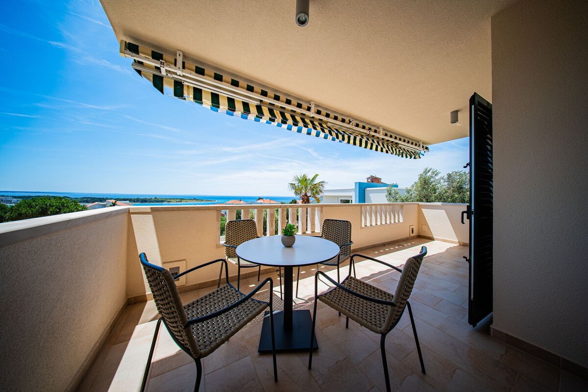 Ein Balkon mit Tisch und Stühlen mit Blick auf die Küste.