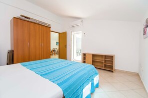 Ένα υπνοδωμάτιο με ένα κρεβάτι, μια ξύλινη ντουλάπα και ένα μικρό γραφείο.