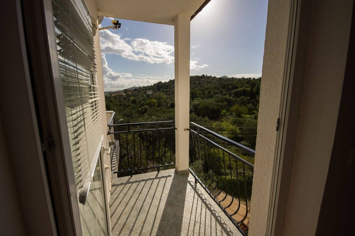 A balcony with a view of a forested hillside.