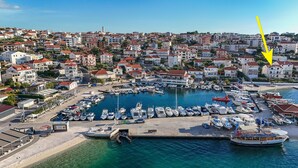 A marina with numerous boats docked, surrounded by residential buildings. - Apartment Natali (Okrug)