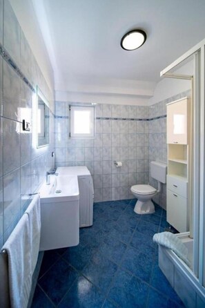 Ein Badezimmer mit Waschbecken, Toilette und Spiegel.