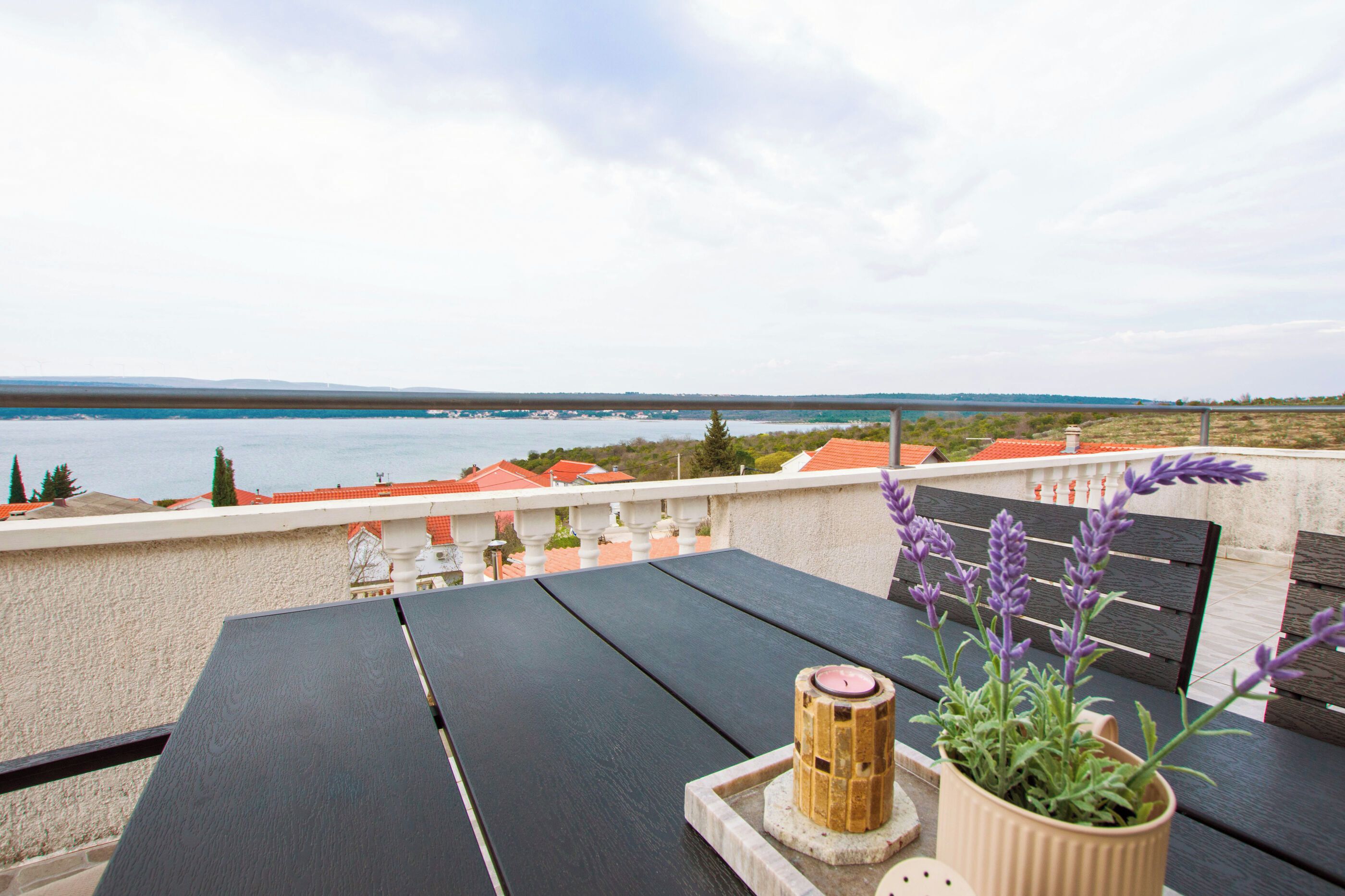 A terrace with a table, a candle holder, and a potted plant.