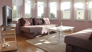 A cozy room with a sofa, a TV, and a table. - Apartments Marin (Biograd na Moru)