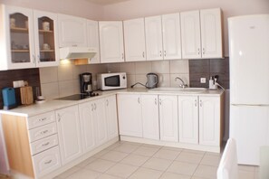 Apartamento (A2) | Cozinha privada | Geladeira, cooktop, talheres/pratos/utensílios de cozinha, freezer