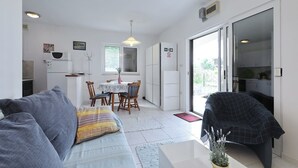 Ein gemütlicher, kleiner Wohnbereich mit Sofa, Esstisch und Küchenzeile.