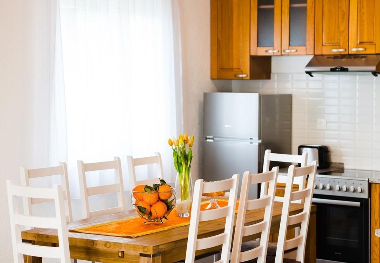 A kitchen with white cabinets, a stainless steel refrigerator, and a stove.