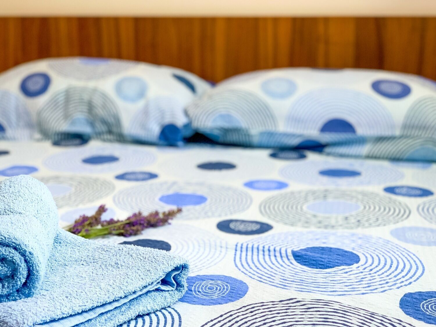 Un lit avec une couvre-lit à motifs et deux oreillers.