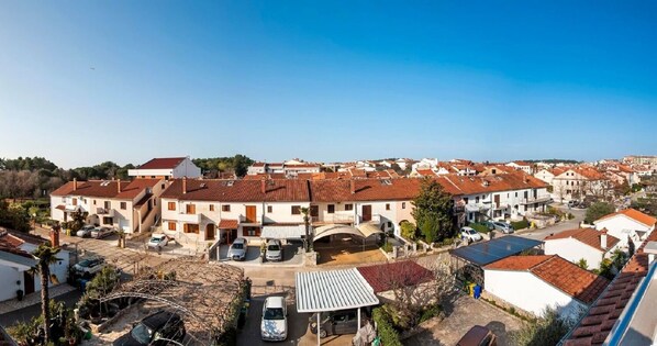 A residential area with red-tiled roofs, white buildings, and a clear blue sky. - Apartments Marija (Rovinj)