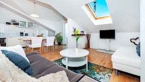 Eine moderne Wohnung mit Essbereich, Küche, Wohnzimmer und einem Oberlicht.