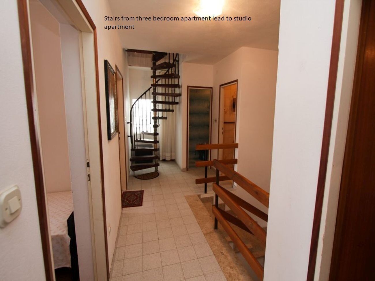 Ein Flur mit einer Wendeltreppe, die zu einem Studio-Apartment führt.