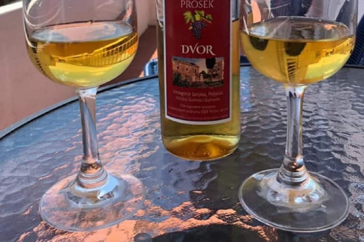 Two wine glasses on a table with a bottle of wine.