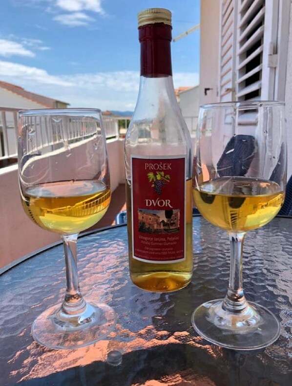Two wine glasses on a table with a bottle of wine. - Apartments Boris (Orebic)