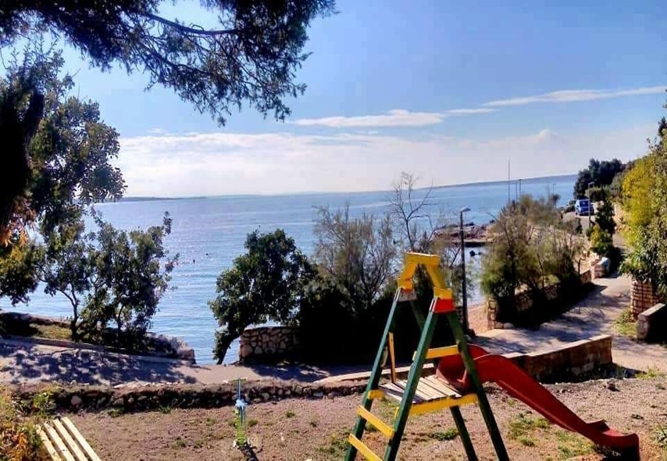 Un parque infantil con tobogán y estructura para escalar cerca del agua.