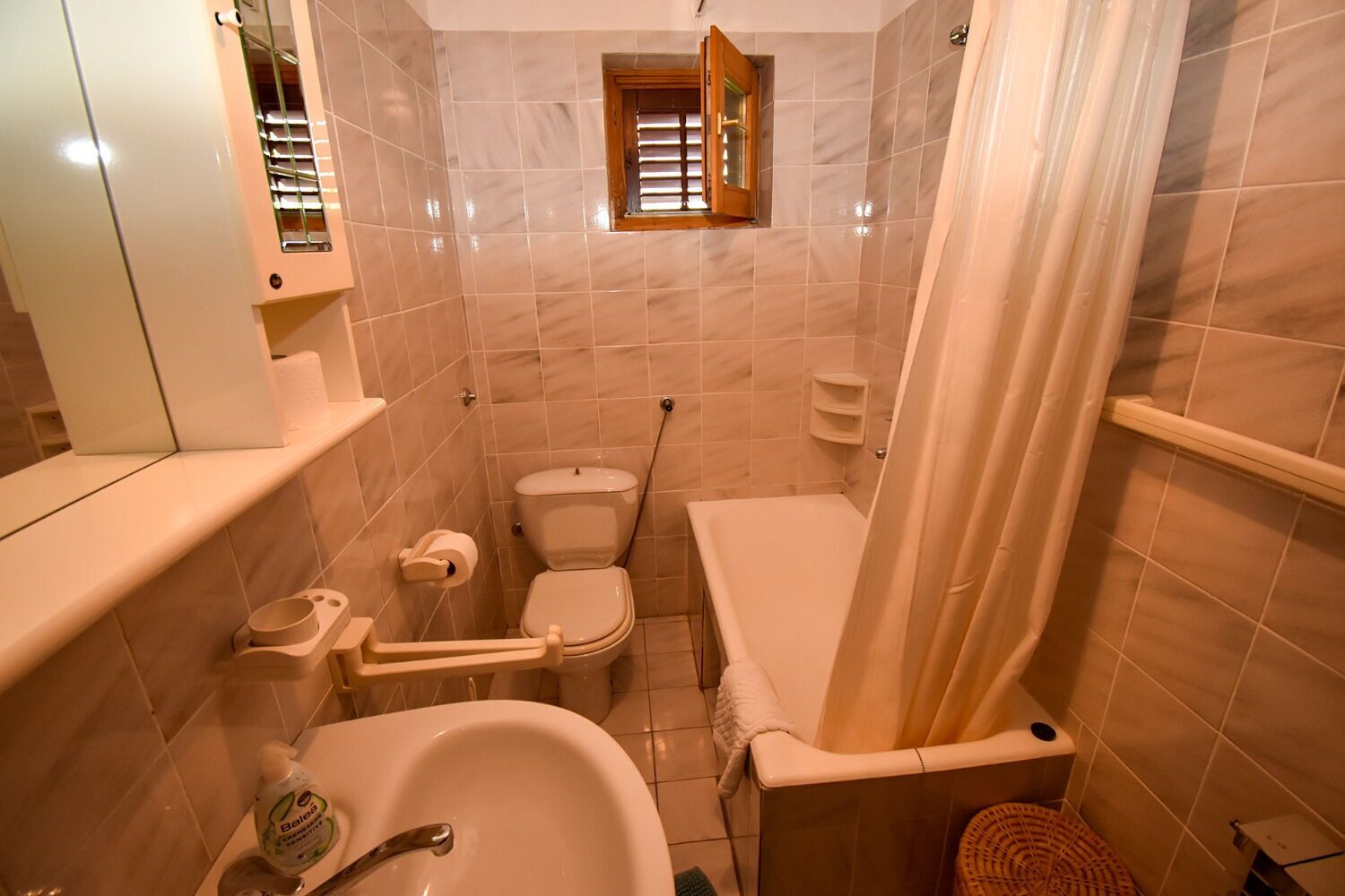 Une salle de bain avec des toilettes, un lavabo et une baignoire.