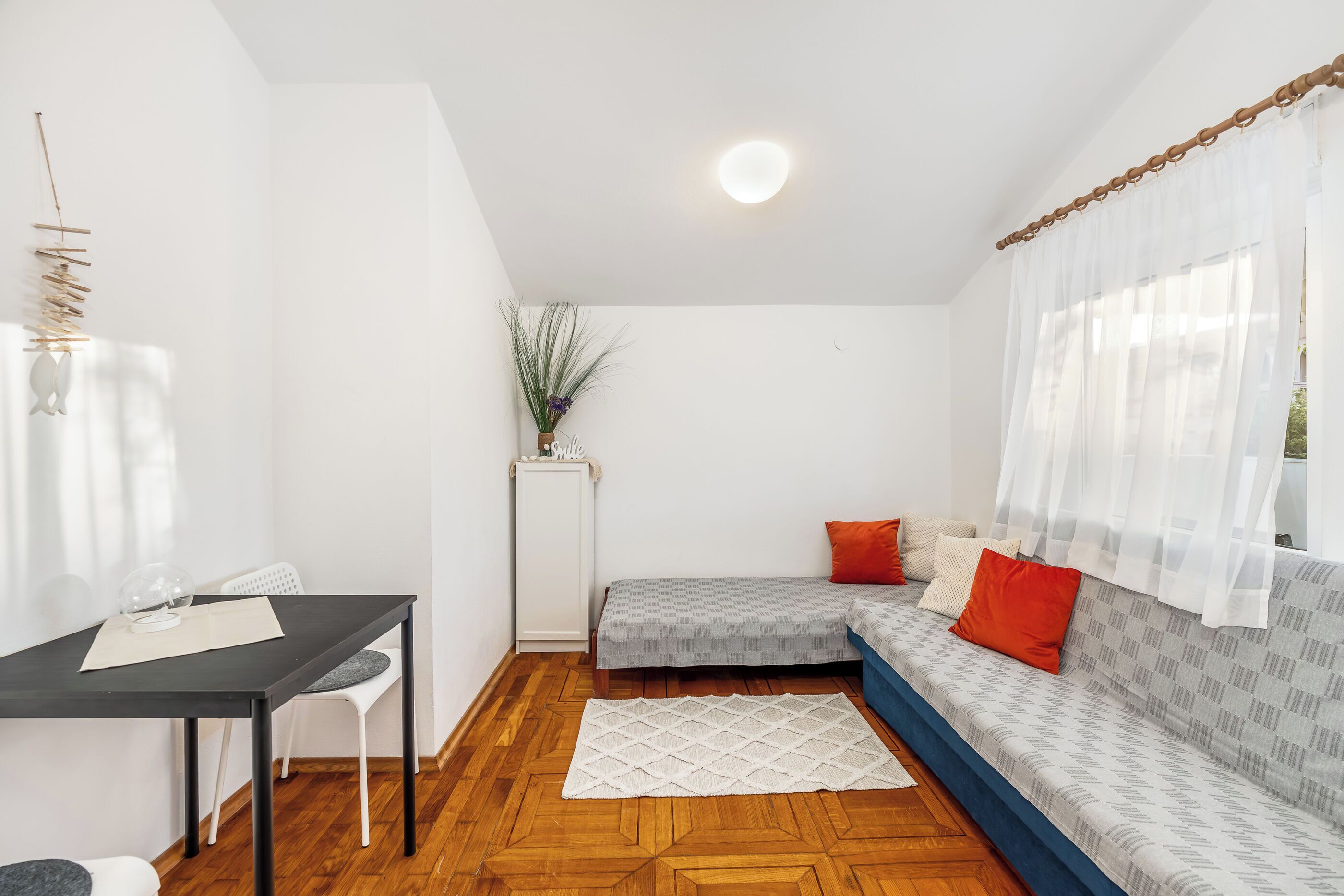 A compact room with a bed, a small table, and a chair.
