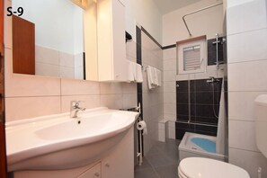 Ein modernes Badezimmer mit Waschbecken, Toilette und Dusche.