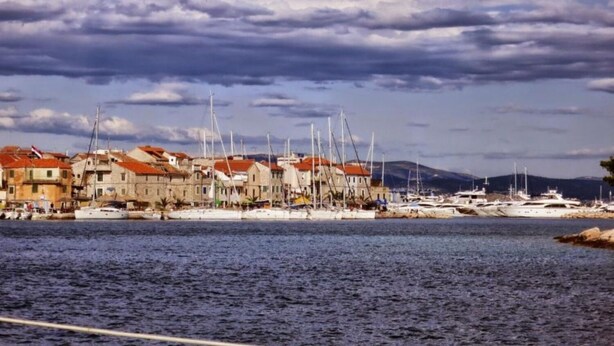 A coastal town with historic buildings and a marina with boats. - Apartment Ivica (Tribunj)