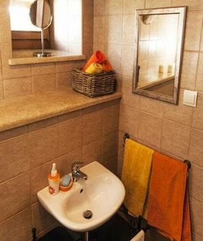 Ein Badezimmer mit Waschbecken, Spiegel und Handtuchhalter.