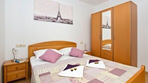 Ein Schlafzimmer mit einem Bett, einem Holzschrank und einem Bild des Eiffelturms.
