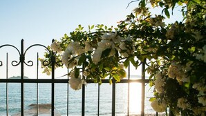 A metal fence with white flowers and a view of the sea. - House Villa Oaza (Rogoznica)