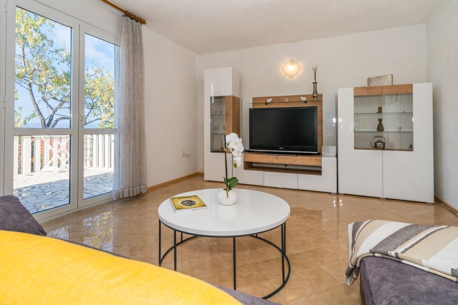 A living room with a TV, a round table, and a sofa.