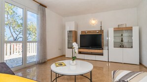 A living room with a TV, a round table, and a sofa. - Apartment Ivan (Solta)