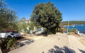 A coastal property with a paved driveway, parked cars, and a view of the sea. - Apartment Angie (Solta)